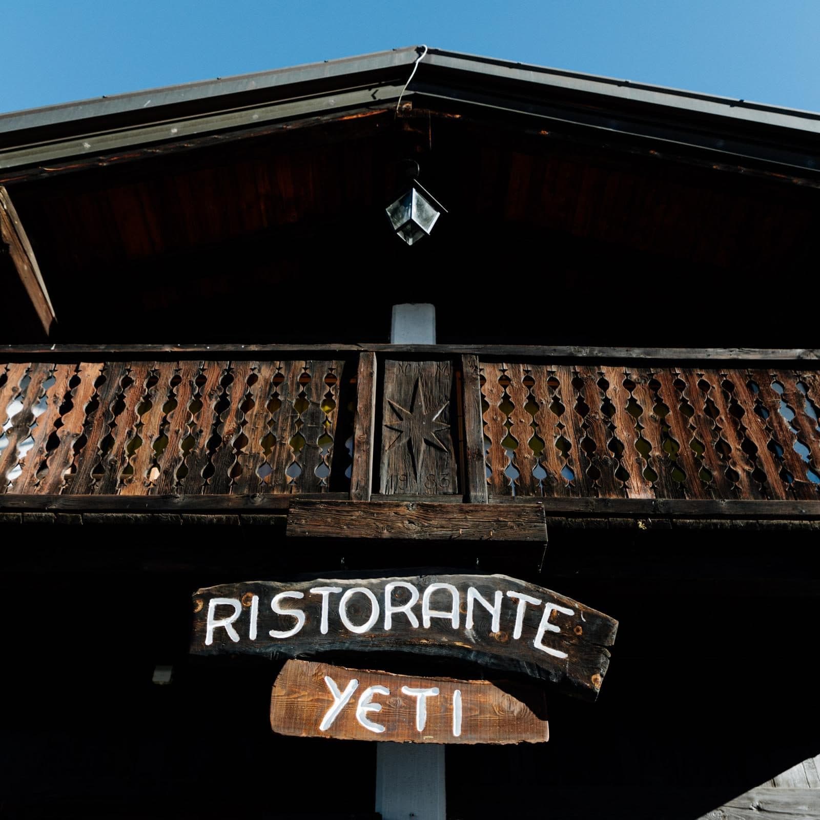 The carved wooden “Ristorante Yeti” sign under the chalet balcony